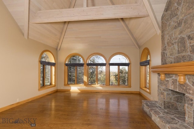 2421 Highland Blvd, Bozeman, MT 59715 - unfurnished living room with wood finished floors, high vaulted ceiling, baseboards, a stone fireplace, and wood ceiling with exposed beams