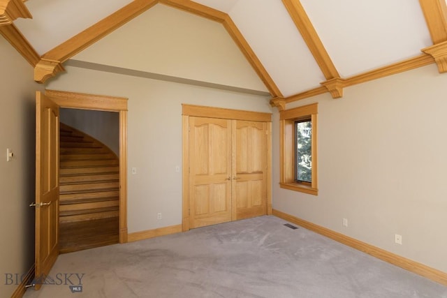 2421 Highland Blvd, Bozeman, MT 59715 - unfurnished bedroom with carpet, baseboards, beam ceiling, a closet, and high vaulted ceiling