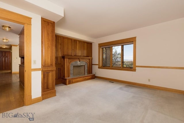 2421 Highland Blvd, Bozeman, MT 59715 - unfurnished living room with baseboards, a fireplace with raised hearth, and light colored carpet