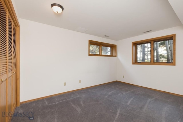 2421 Highland Blvd, Bozeman, MT 59715 - unfurnished bedroom with multiple windows, dark colored carpet, and baseboards