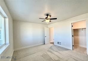 17 Durango Trl, Three Forks, MT 59752 - unfurnished bedroom featuring multiple windows, a walk in closet, and baseboards