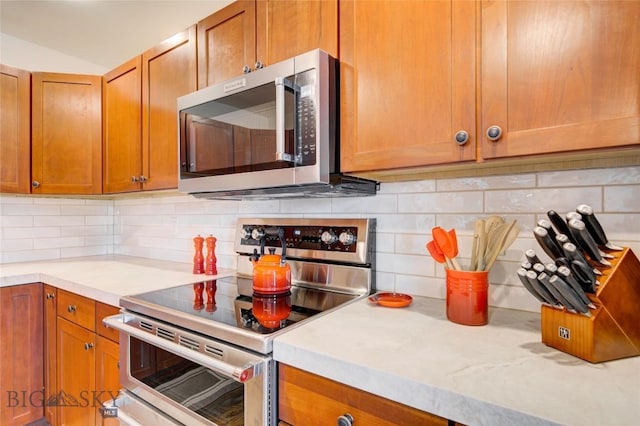 424 E Main St Unit E, Bozeman, MT 59715 - kitchen with stainless steel appliances, decorative backsplash, light countertops, and brown cabinetry