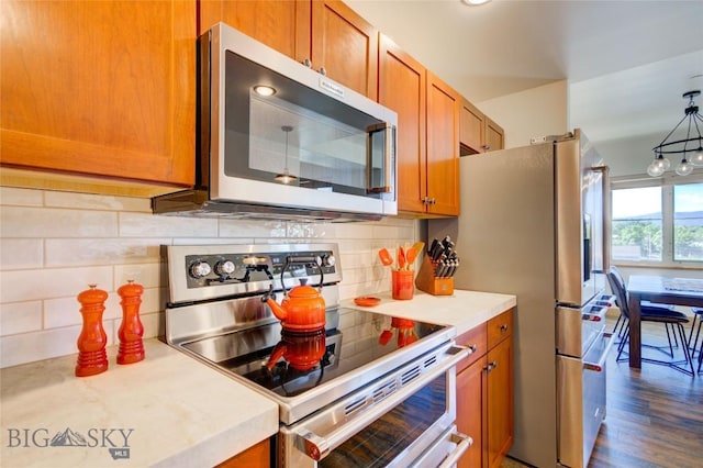 424 E Main St Unit E, Bozeman, MT 59715 - kitchen with appliances with stainless steel finishes, brown cabinetry, and light countertops