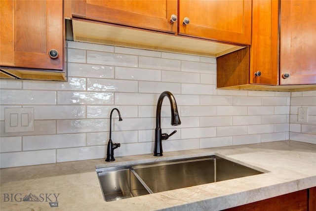 424 E Main St Unit E, Bozeman, MT 59715 - kitchen view of a sink, decorative backsplash, light stone countertops, and brown cabinets