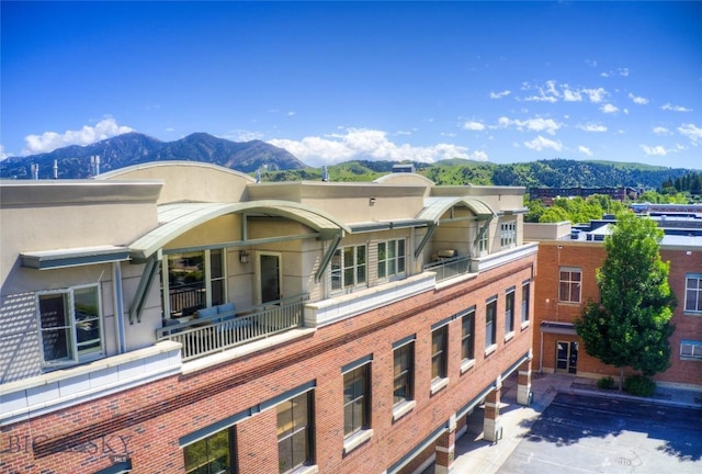 424 E Main St Unit E, Bozeman, MT 59715 - rear view of house with a balcony, a mountain view, and brick siding