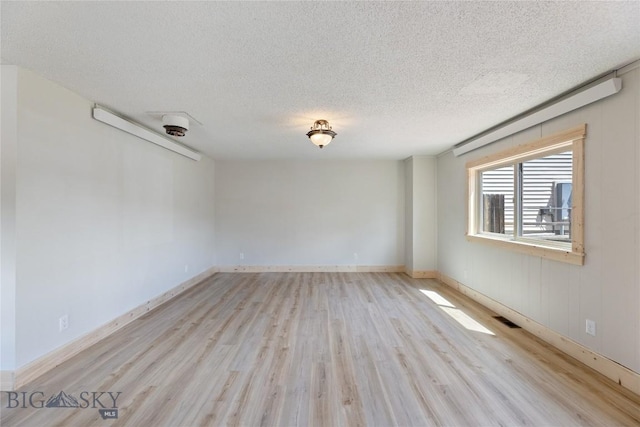 312 Water St, Gardiner, MT 59030 - empty room featuring light wood-style floors, a textured ceiling, and baseboards