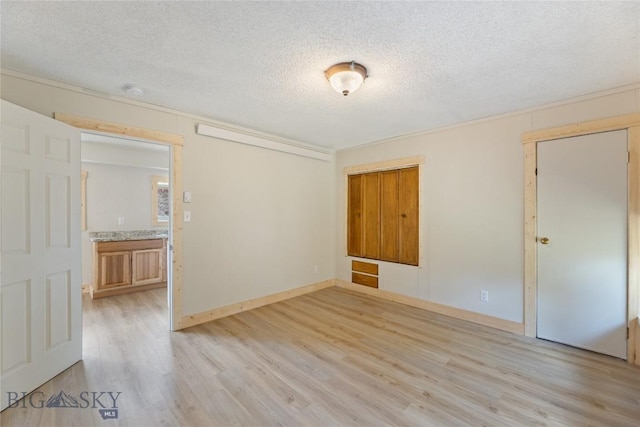 312 Water St, Gardiner, MT 59030 - unfurnished room featuring light wood-type flooring, a textured ceiling, and baseboards