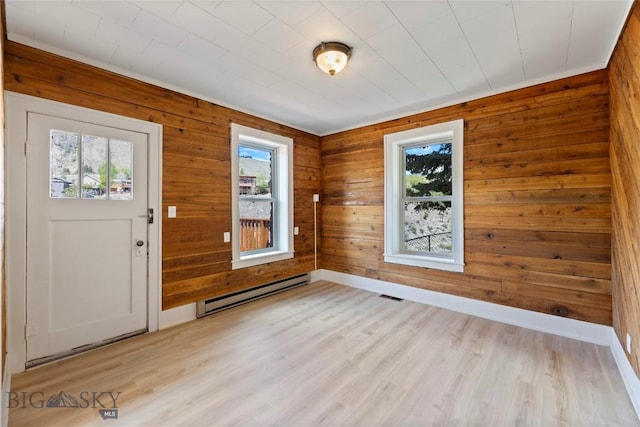 312 Water St, Gardiner, MT 59030 - foyer entrance with a baseboard heating unit, wood walls, light wood-style flooring, and baseboards