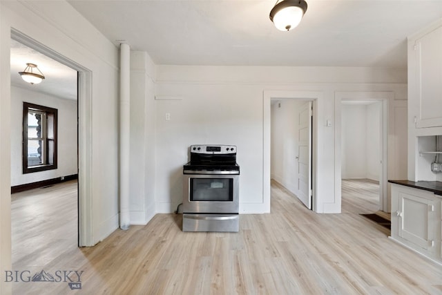 504 4th St, Gardiner, MT 59030 - kitchen with electric stove, dark countertops, white cabinets, and light wood finished floors