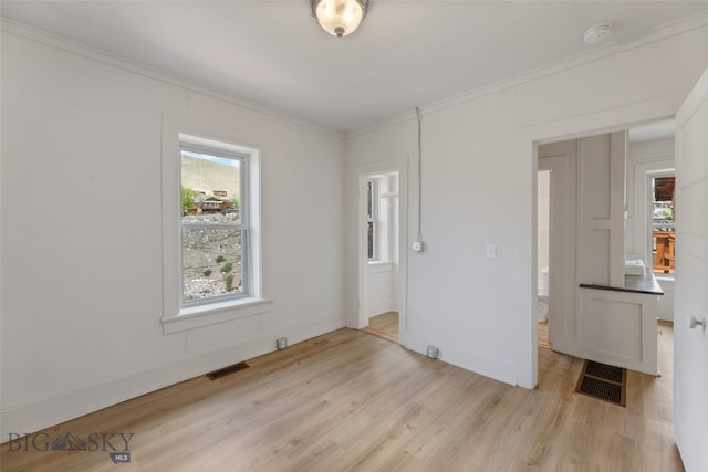 504 4th St, Gardiner, MT 59030 - unfurnished room featuring light wood-style floors, crown molding, healthy amount of natural light, and a smoke detector