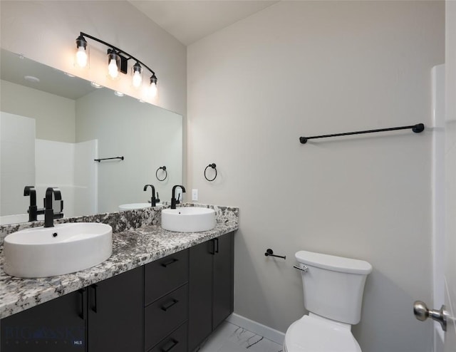 1505 Pistolero Way, Belgrade, MT 59714 - bathroom featuring double vanity, marble finish floors, toilet, and baseboards