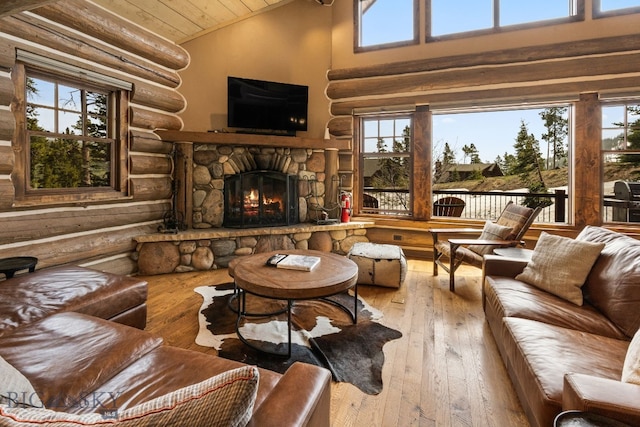 9 Manitou Loop Unit 45E, Big Sky, MT 59716 - living room with rustic walls, hardwood / wood-style floors, wooden ceiling, a stone fireplace, and high vaulted ceiling