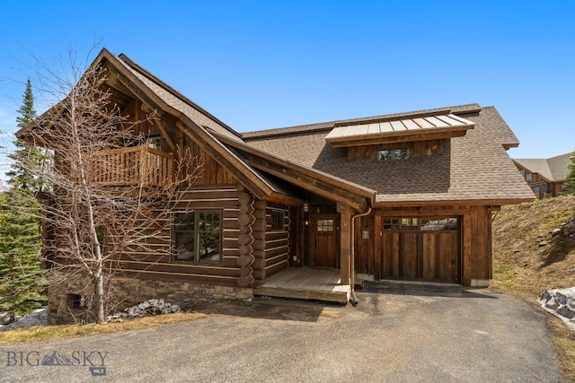 9 Manitou Loop Unit 45E, Big Sky, MT 59716 - log-style house featuring a shingled roof, an attached garage, driveway, and log exterior