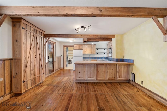 511 Alder St, Anaconda, MT 59711 - kitchen with hardwood / wood-style flooring, a peninsula, washer / clothes dryer, freestanding refrigerator, and light brown cabinetry