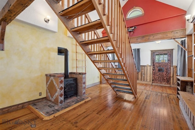 511 Alder St, Anaconda, MT 59711 - unfurnished living room featuring hardwood / wood-style flooring, stairs, a wood stove, and a towering ceiling