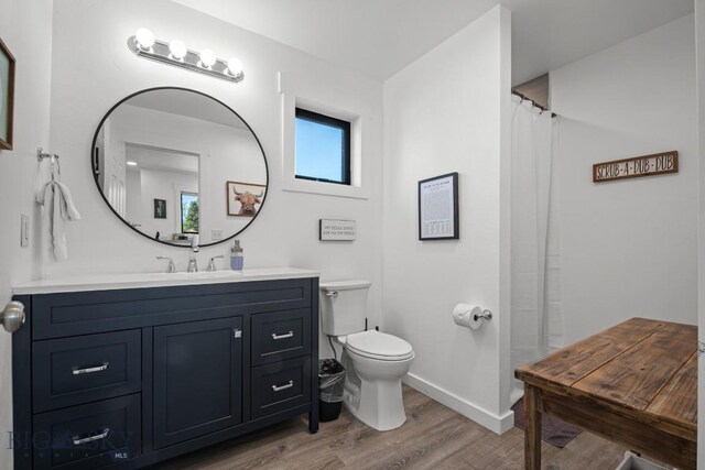 420 N 6th Ave, Bozeman, MT 59715 - bathroom featuring baseboards, wood finished floors, vanity, toilet, and a shower with curtain