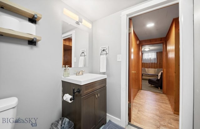 420 N 6th Ave, Bozeman, MT 59715 - bathroom with toilet, vanity, wooden walls, and baseboards