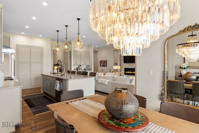 47 Wickwire, Bozeman, MT 59718 - dining space with a chandelier, dark wood finished floors, a stone fireplace, and recessed lighting