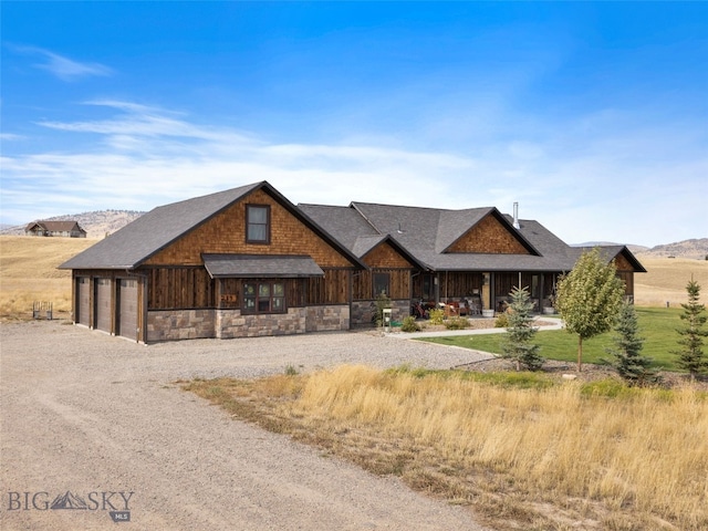 289 Montana Way, Ennis, MT 59729 - view of front of house with stone siding, driveway, and a shingled roof