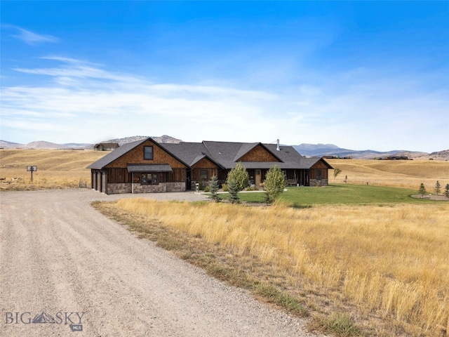 289 Montana Way, Ennis, MT 59729 - view of front of home featuring stone siding, a mountain view, dirt driveway, and a rural view