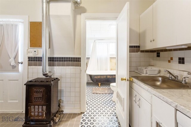 1116-1118 California St, Butte, MT 59701 - full bath with tile walls, vanity, a freestanding tub, a wainscoted wall, and toilet