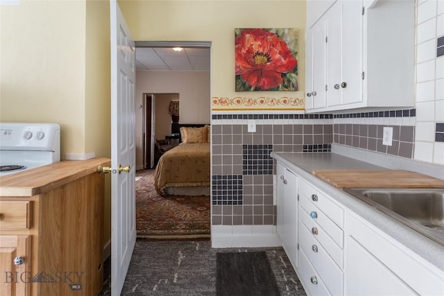 1116-1118 California St, Butte, MT 59701 - kitchen featuring white cabinetry, a drop ceiling, wooden counters, tile walls, and dark carpet