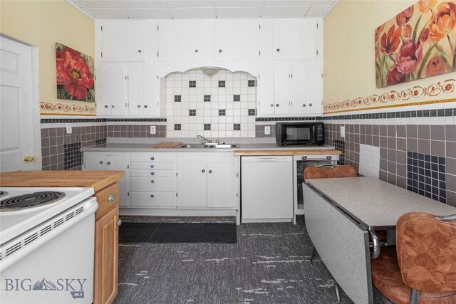 1116-1118 California St, Butte, MT 59701 - kitchen with white appliances, tile walls, a sink, white cabinetry, and a wainscoted wall