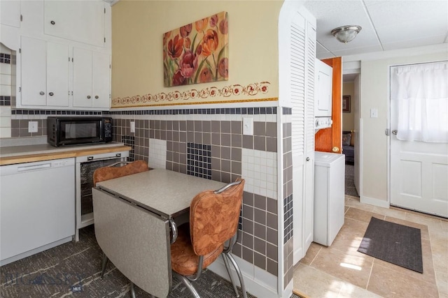 1116-1118 California St, Butte, MT 59701 - kitchen featuring black microwave, dishwasher, tile walls, light countertops, and white cabinetry