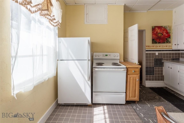 1116-1118 California St, Butte, MT 59701 - kitchen featuring white appliances, light countertops, a paneled ceiling, and dark tile patterned flooring