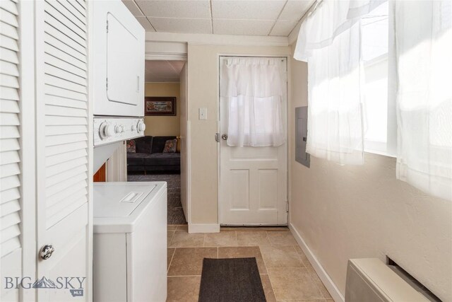1116-1118 California St, Butte, MT 59701 - laundry area featuring stacked washing machine and dryer, baseboards, electric panel, and light tile patterned flooring