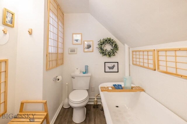 304 W Granite St, Butte, MT 59701 - bathroom with wood finished floors, toilet, lofted ceiling, and a soaking tub