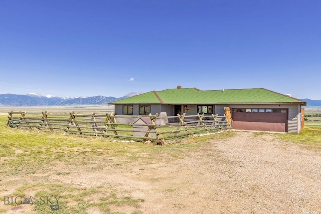 25 Trail Creek Rd, Ennis, MT 59729 - view of front of house with a garage, dirt driveway, an exterior structure, a mountain view, and an outdoor structure