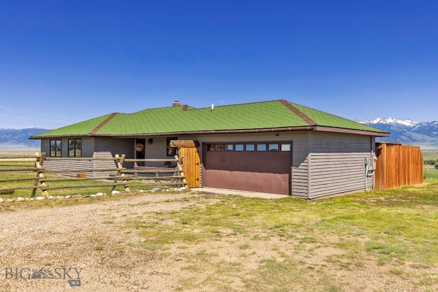 25 Trail Creek Rd, Ennis, MT 59729 - view of front of property featuring a mountain view, an exterior structure, an attached garage, an outbuilding, and a chimney