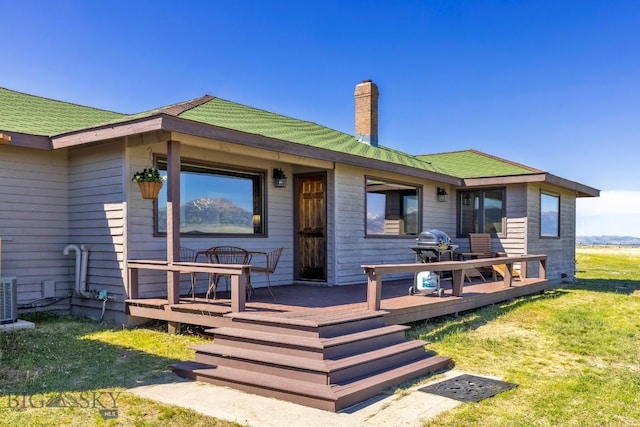 25 Trail Creek Rd, Ennis, MT 59729 - rear view of house with a chimney, a wooden deck, a yard, and cooling unit
