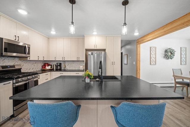 420 N 6th Ave, Bozeman, MT 59715 - kitchen with stainless steel appliances, a sink, light wood-style flooring, backsplash, and dark countertops