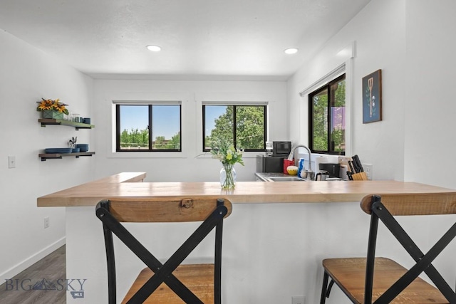 420 N 6th Ave, Bozeman, MT 59715 - kitchen with a sink, wood finished floors, a breakfast bar, recessed lighting, and baseboards