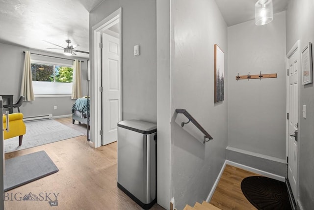 420 N 6th Ave, Bozeman, MT 59715 - hallway featuring a baseboard heating unit, wood finished floors, baseboards, and an upstairs landing