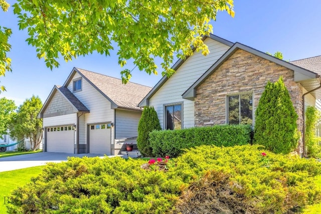 510 N 23rd, Bozeman, MT 59718 - view of front of home featuring stone siding, a garage, driveway, and a shingled roof