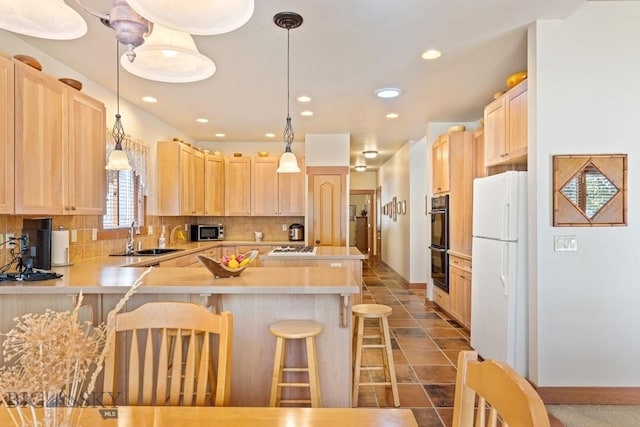 510 N 23rd, Bozeman, MT 59718 - kitchen featuring a sink, freestanding refrigerator, light brown cabinetry, stainless steel microwave, and a peninsula