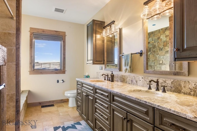 715 Bates Rd, Manhattan, MT 59741 - full bath featuring double vanity, baseboards, stone tile flooring, toilet, and tiled shower