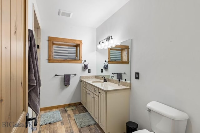 715 Bates Rd, Manhattan, MT 59741 - bathroom with toilet, vanity, wood finished floors, and baseboards