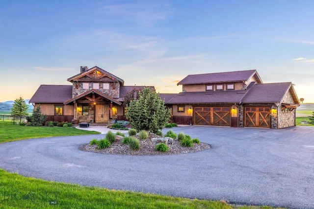 715 Bates Rd, Manhattan, MT 59741 - view of front of property with stone siding, driveway, a tiled roof, a yard, and an attached garage
