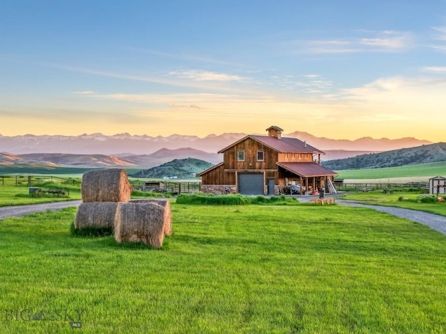 715 Bates Rd, Manhattan, MT 59741 - view of front facade featuring driveway, a mountain view, a front lawn, and a chimney