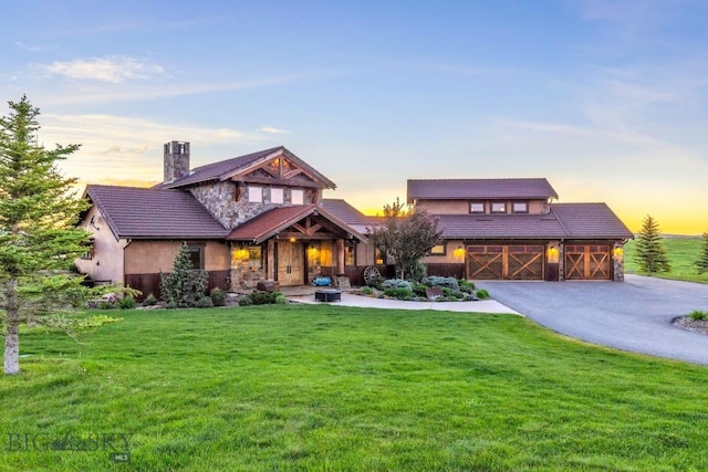 715 Bates Rd, Manhattan, MT 59741 - view of front facade featuring a lawn, stone siding, a porch, asphalt driveway, and stucco siding