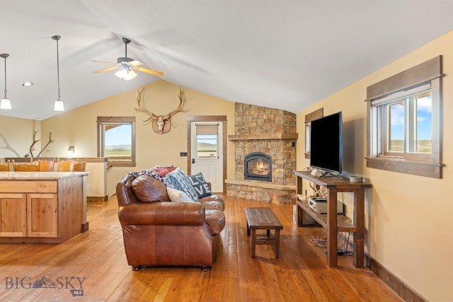715 Bates Rd, Manhattan, MT 59741 - living area featuring a ceiling fan, light wood finished floors, a stone fireplace, lofted ceiling, and baseboards