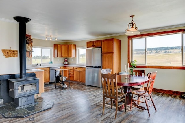 996 Forest Grove Rd, Lewistown, MT 59457 - dining space featuring a wood stove, ornamental molding, dark wood-style floors, baseboards, and track lighting