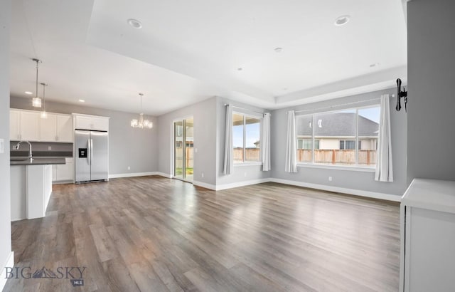 1518 Deadwood Loop, Belgrade, MT 59714 - unfurnished living room featuring plenty of natural light, a chandelier, wood finished floors, recessed lighting, and baseboards