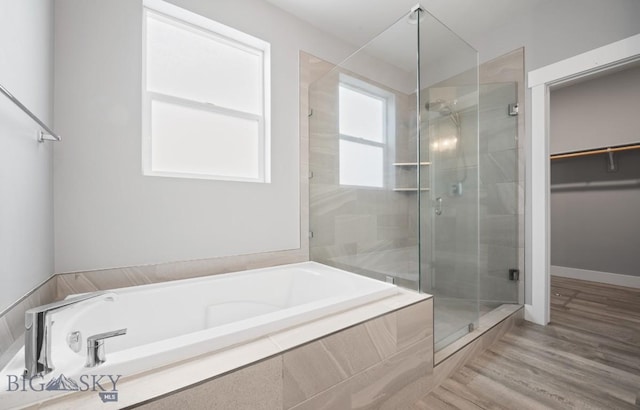 1518 Deadwood Loop, Belgrade, MT 59714 - bathroom with a shower stall, a bath, a walk in closet, and wood finished floors