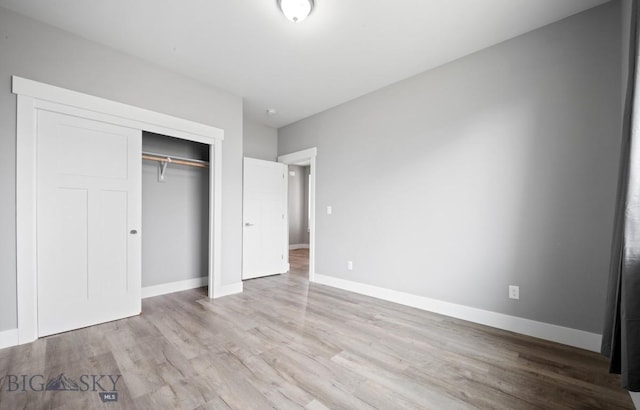 1518 Deadwood Loop, Belgrade, MT 59714 - unfurnished bedroom with wood finished floors, a closet, and baseboards
