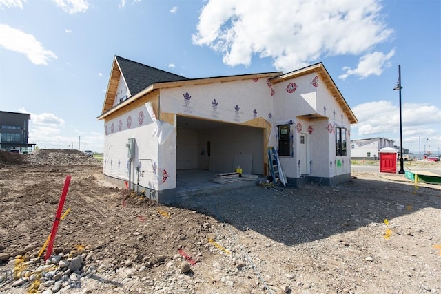 500 Spaniel Ln, Belgrade, MT 59714 - rear view of house with gravel driveway, a garage, and stucco siding
